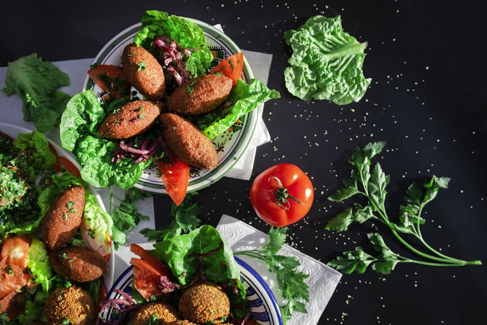 two plates of food with lettuce and tomatoes