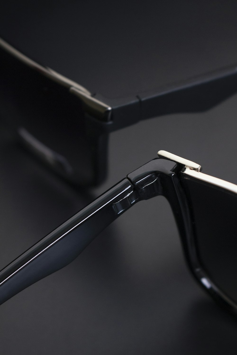a pair of black sunglasses on a black surface