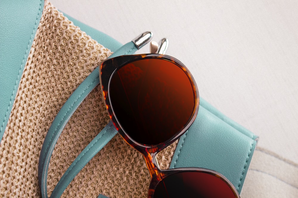 a pair of sunglasses sitting on top of a purse
