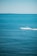 A person riding a jet ski across a vibrant blue ocean.