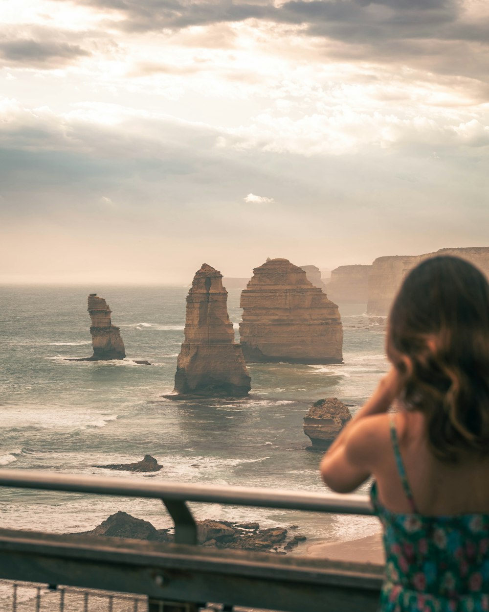 a woman standing on a balcony looking at the ocean