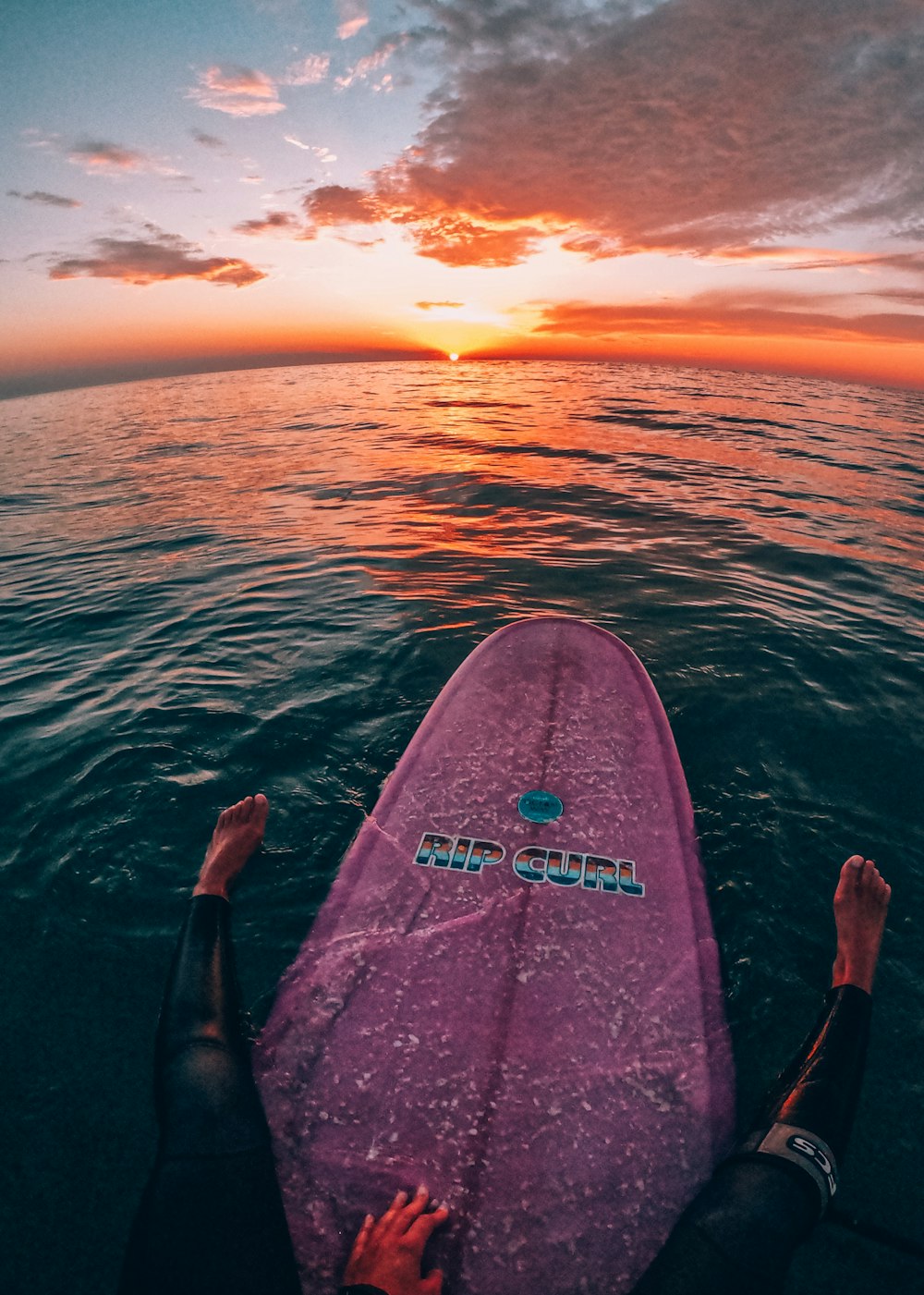 a person laying on a surfboard in the water