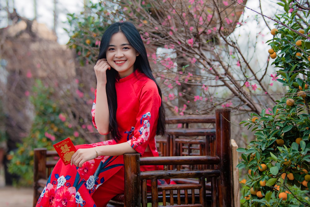 a woman in a red dress sitting on a bench