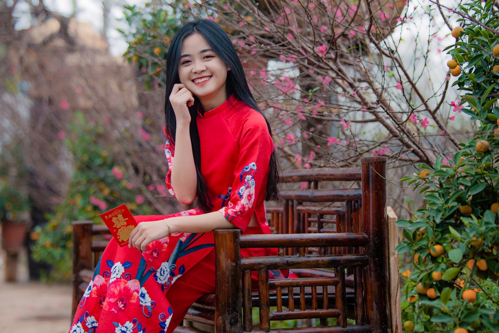 a woman in a red dress sitting on a bench