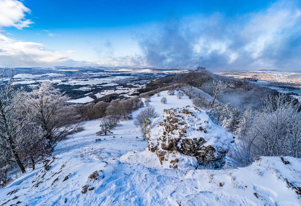 a snow covered hill with a blue sky in the background