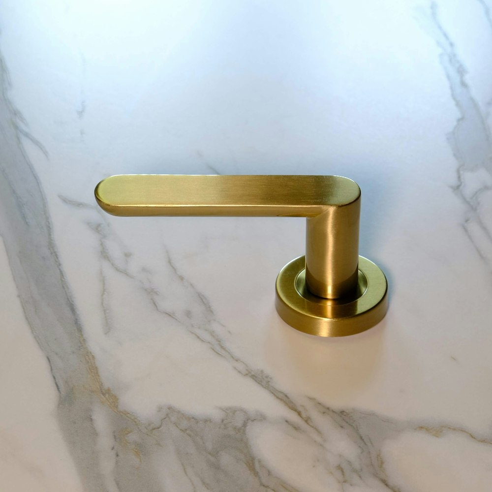 a gold handle on a marble counter top