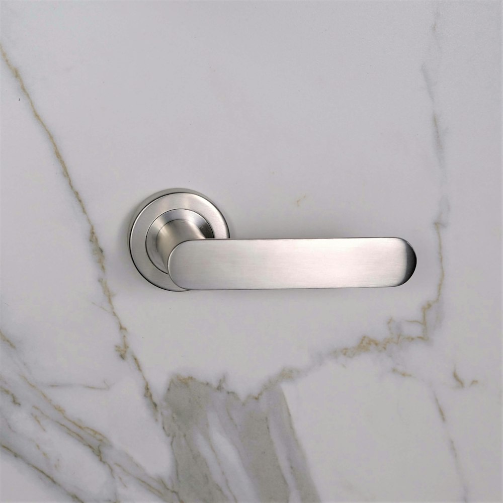 a close up of a door handle on a marble surface