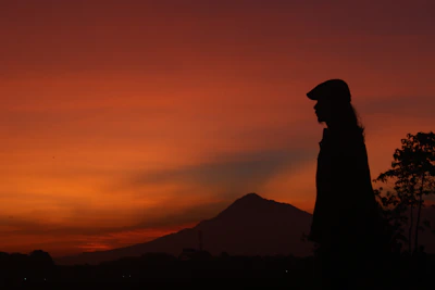 A scenic outdoor shot of a sunset with a silhouette of a cowboy hat and star-shaped jewelry.