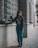 a woman standing next to a window on a sidewalk