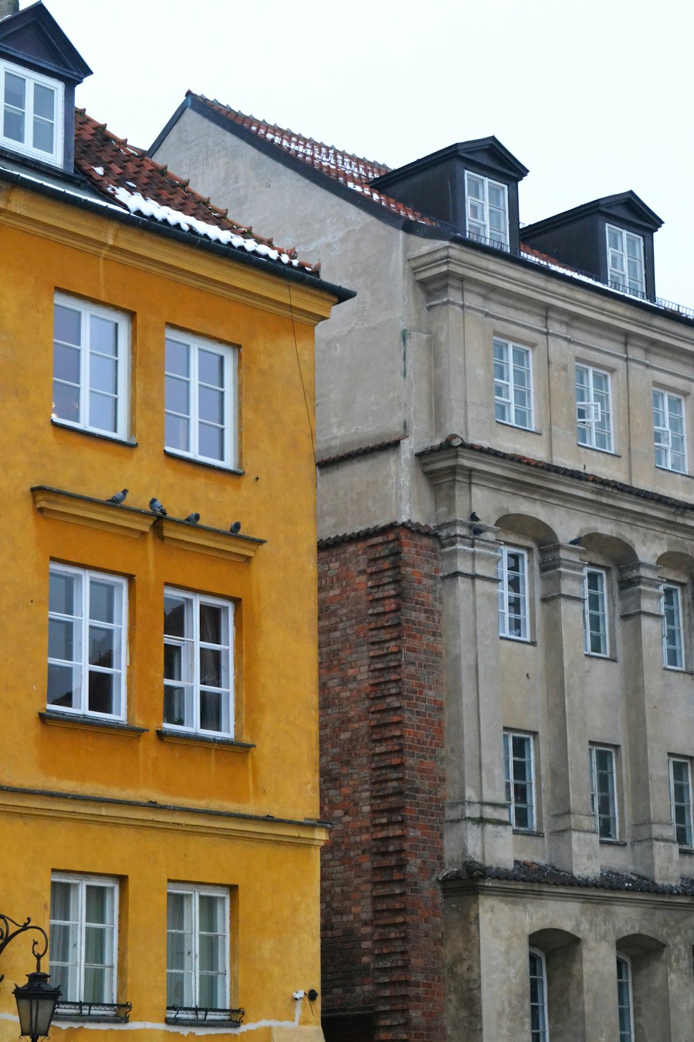 a clock on a pole in front of a row of buildings