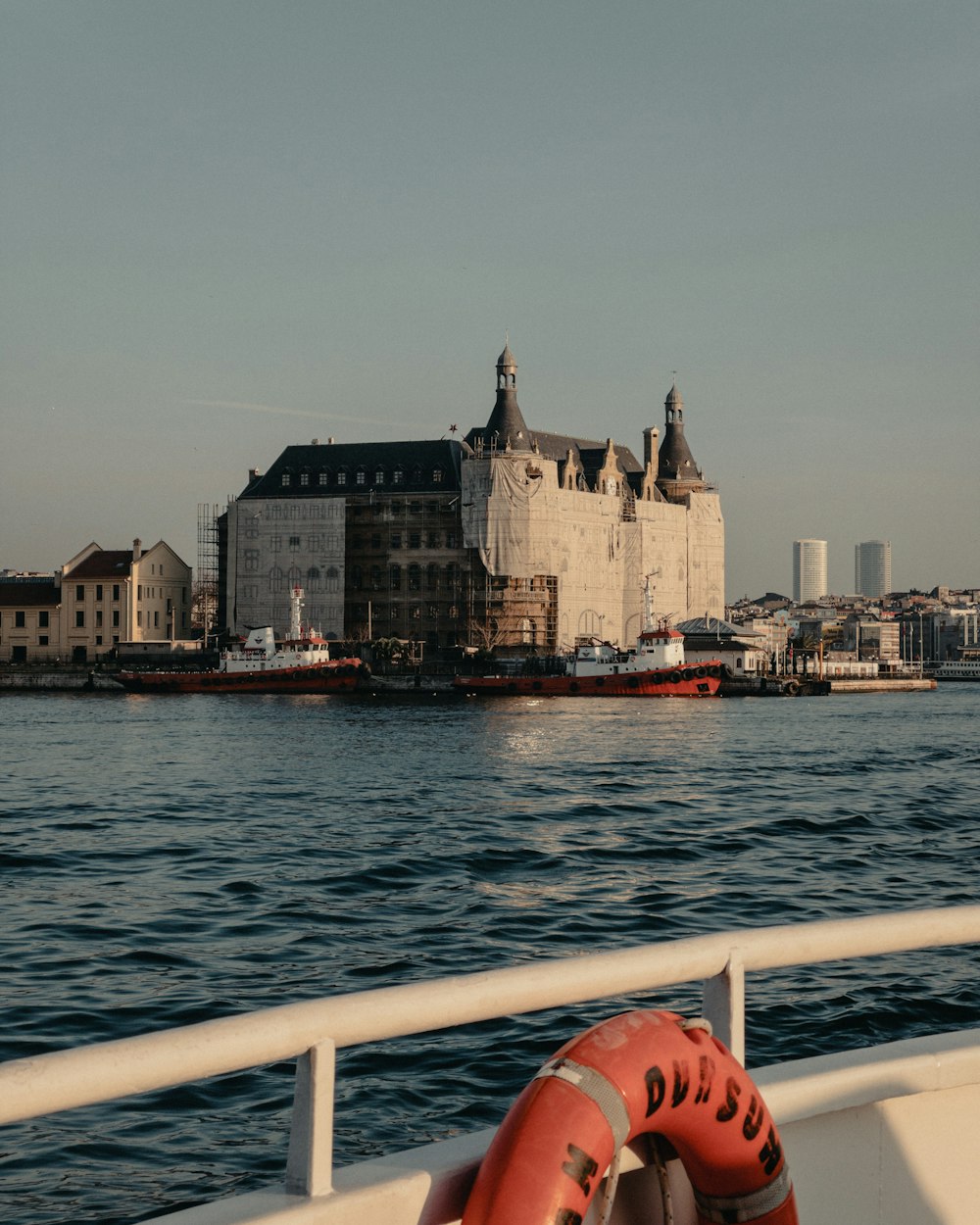 um barco que viaja por um rio ao lado de um grande edifício