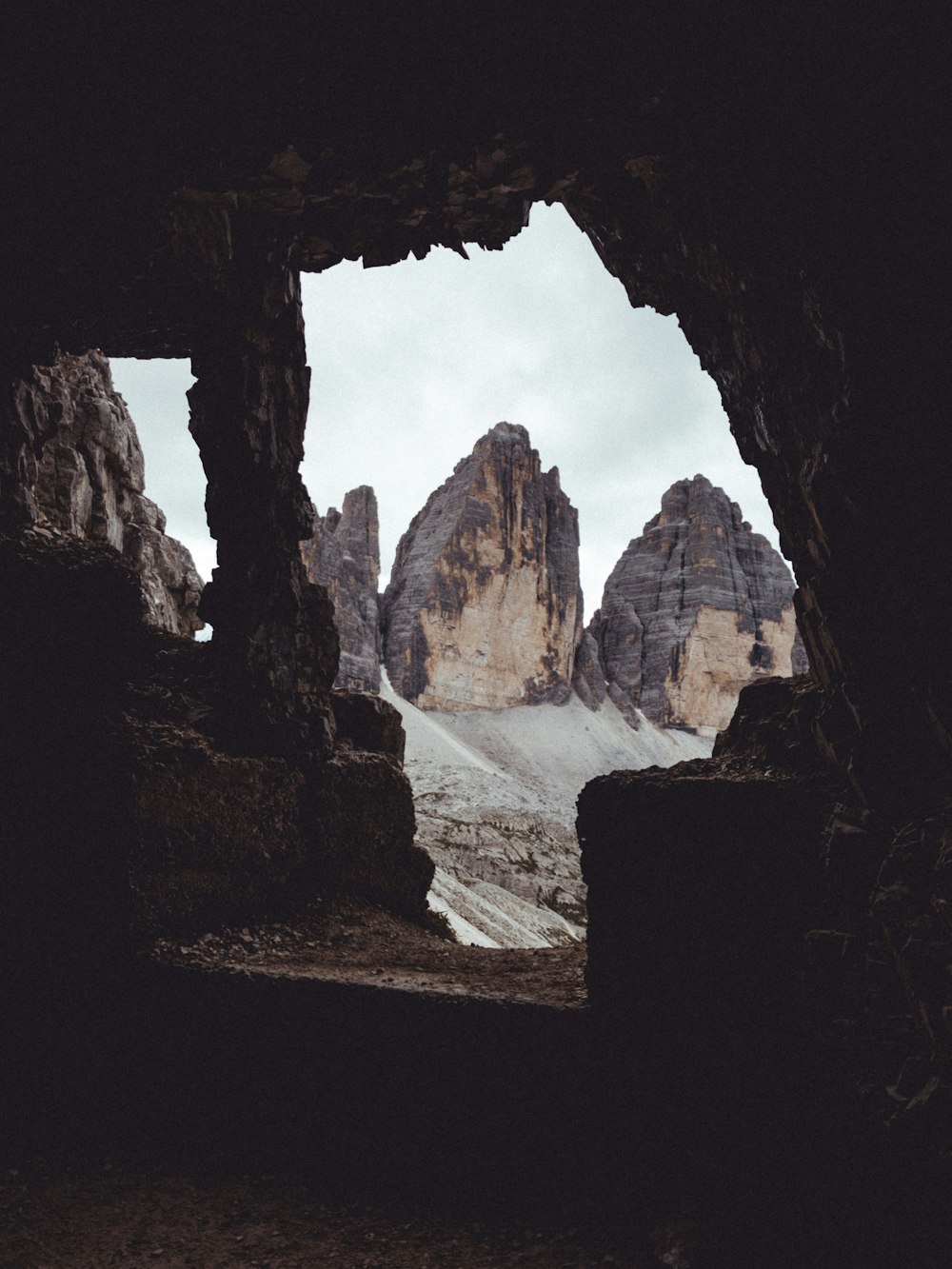 a view of a mountain range through a cave