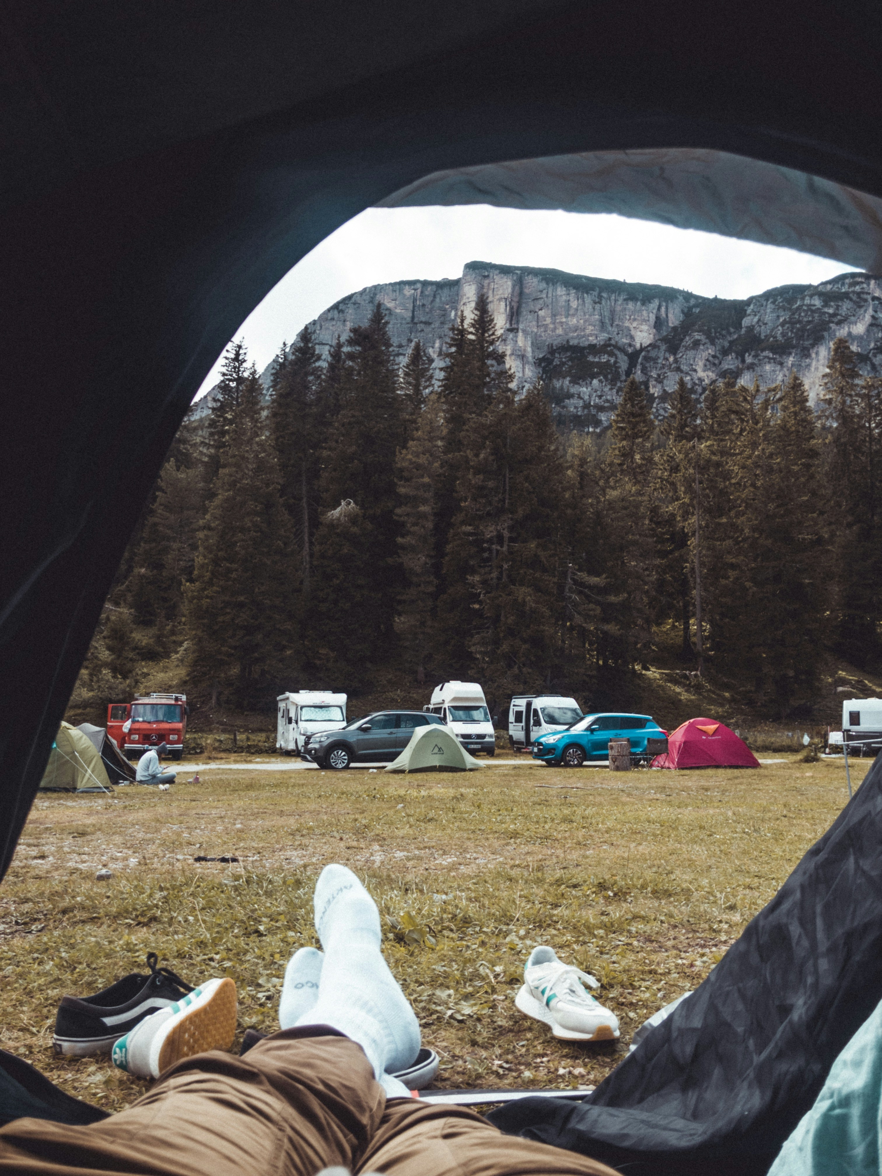 a person laying in a tent in front of a mountain