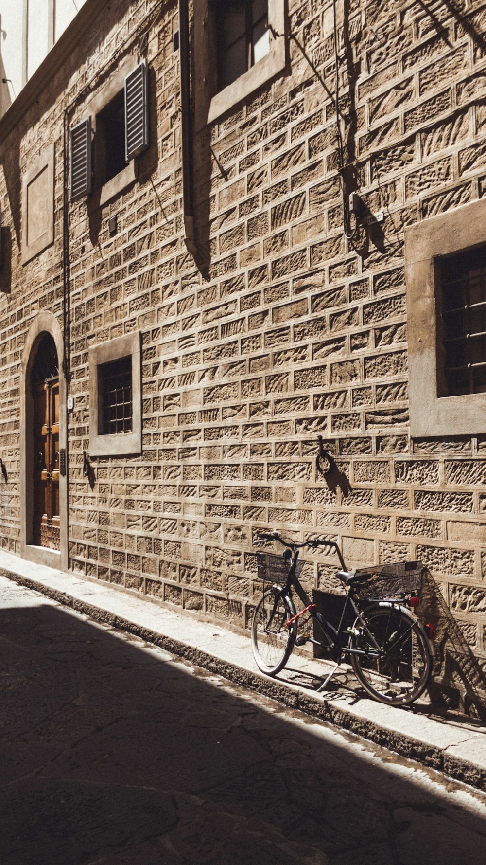 a bike leaning against a brick wall on a street