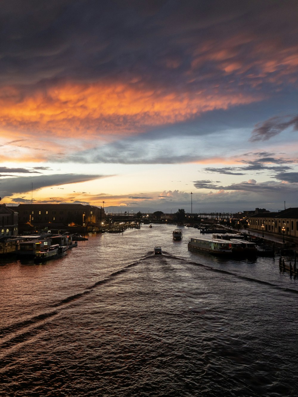 a boat traveling down a river under a cloudy sky