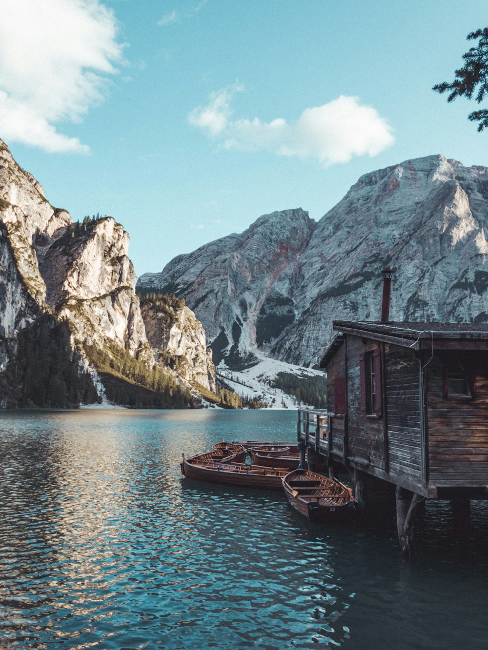 two boats are tied to a dock in a mountain lake