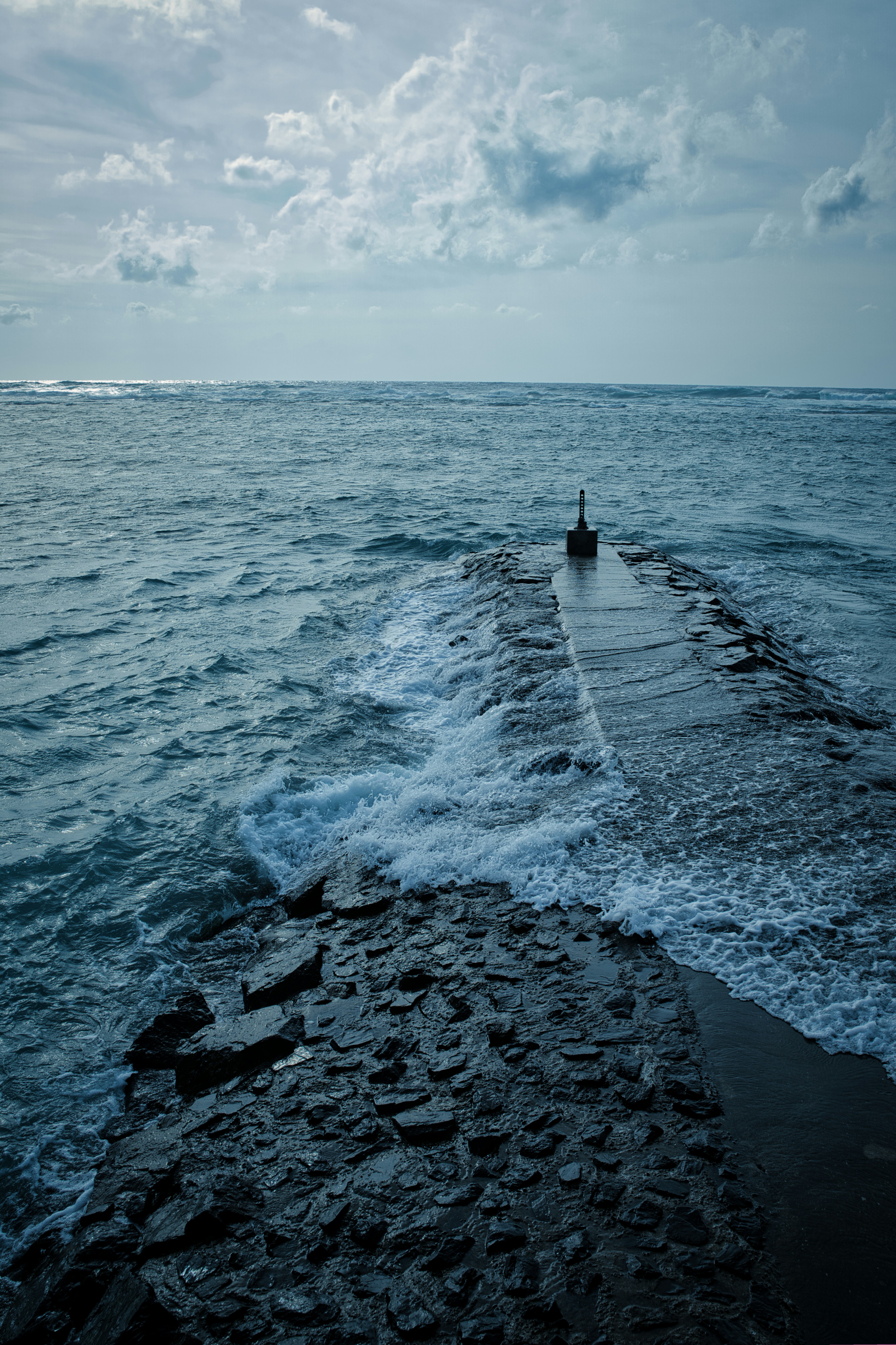 a person standing on a pier in the middle of the ocean