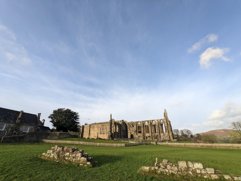 a large stone building sitting on top of a lush green field