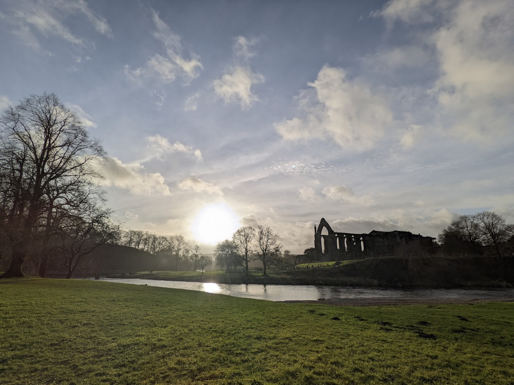 the sun is setting over a river in a park