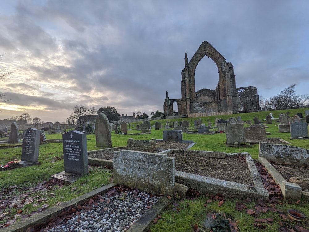 a cemetery with a large stone building in the background