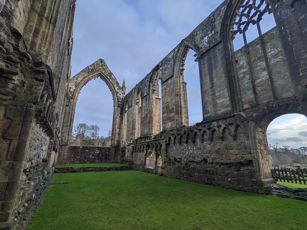 the ruins of an old church with a green lawn