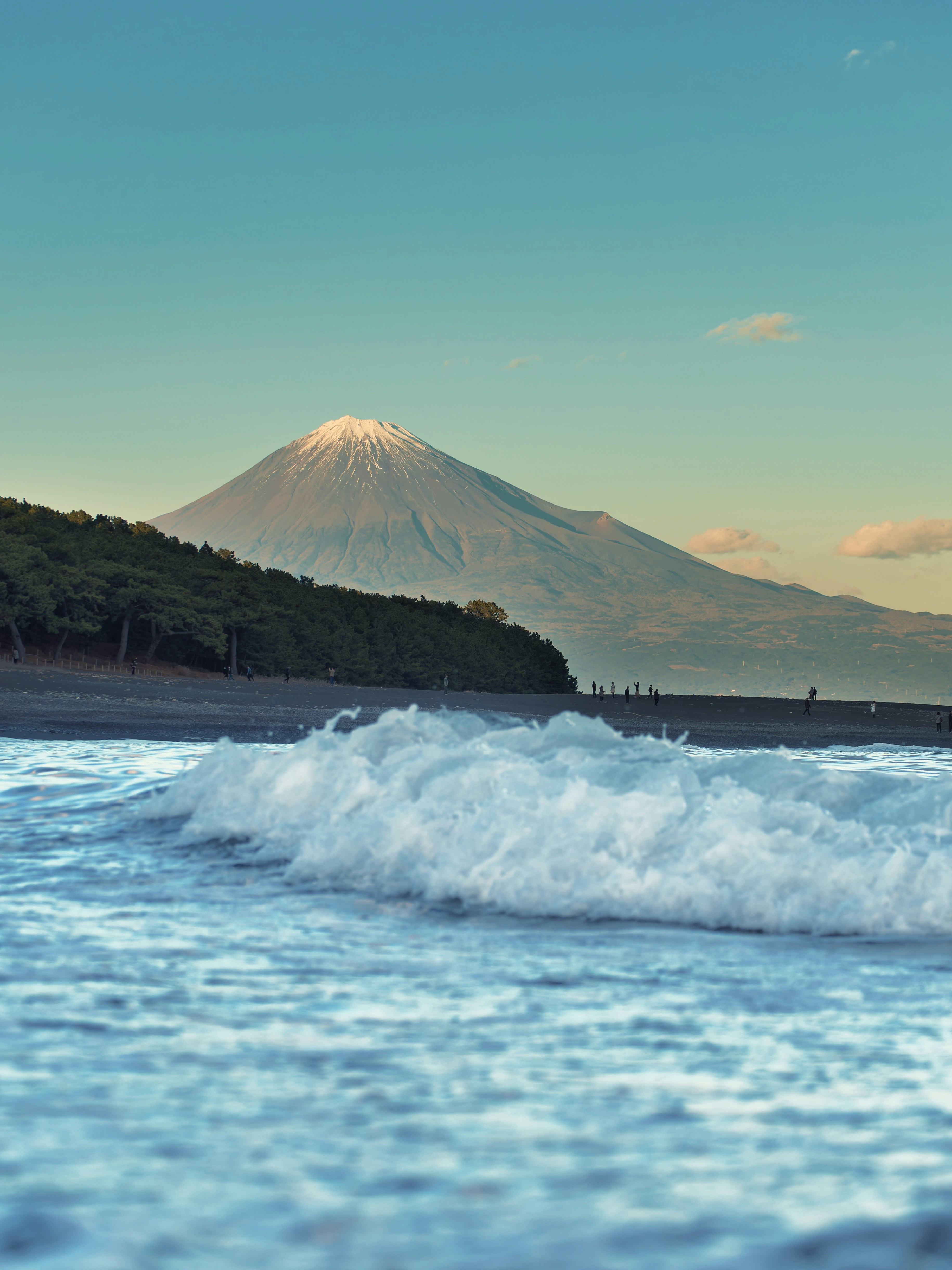 a wave is coming in front of a mountain
