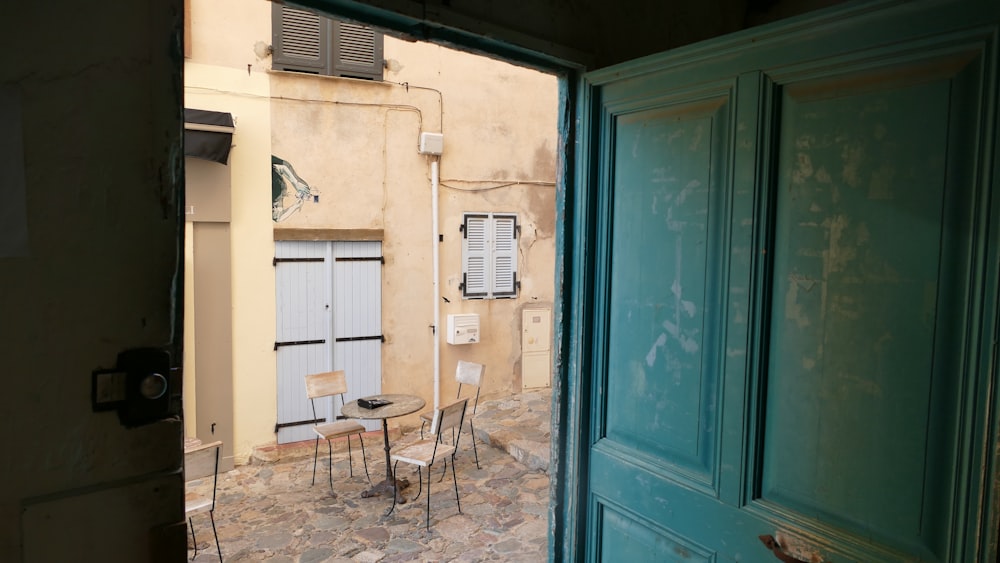 an open door leading to a patio with a table and chairs