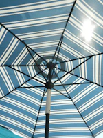 Close-up of a durable fabric parasol casting a gentle shadow on a sunlit patio.