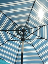 Close-up of a sturdy patio umbrella base anchoring a vibrant umbrella on a sunny day.