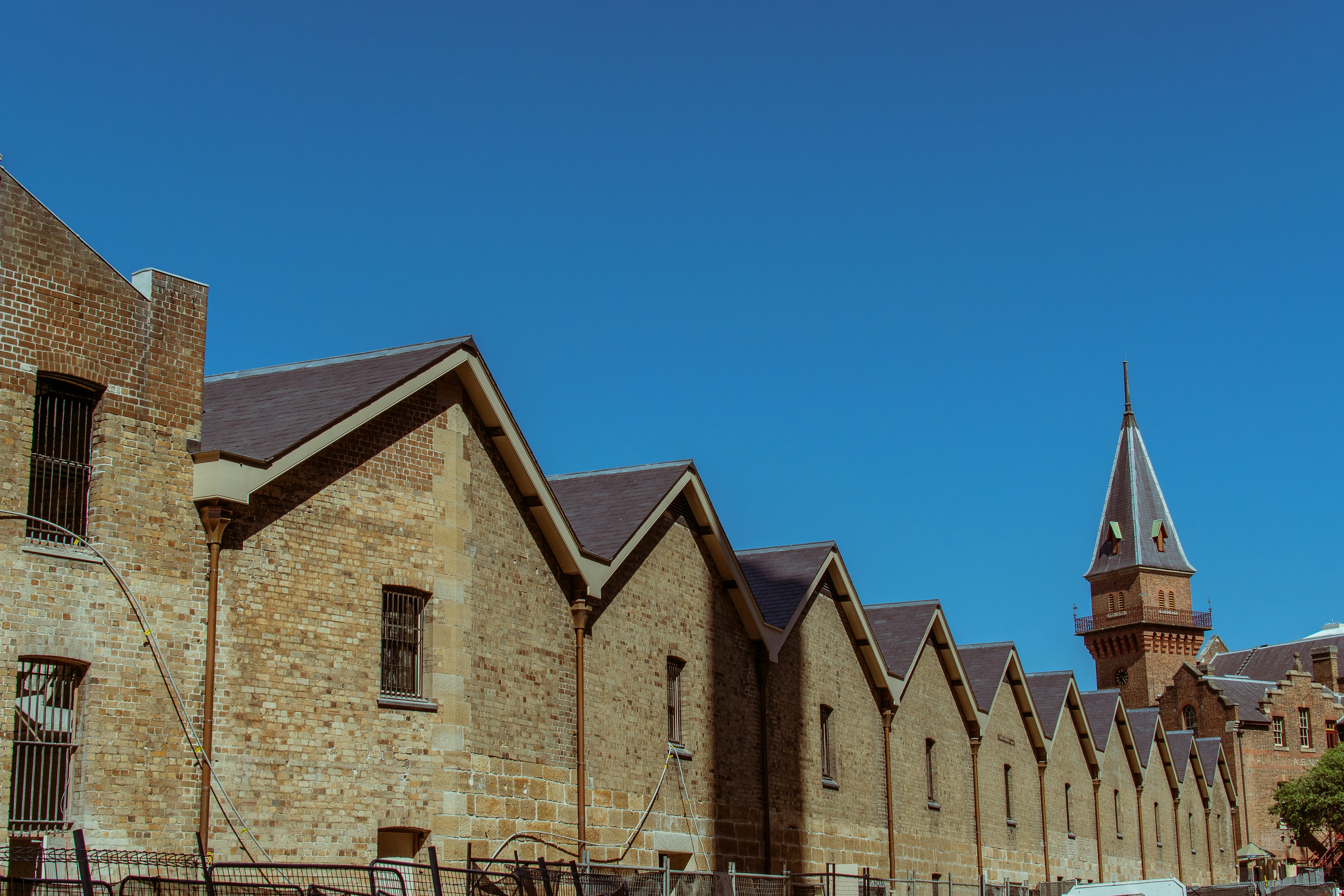 a row of brick buildings with a clock tower in the background
