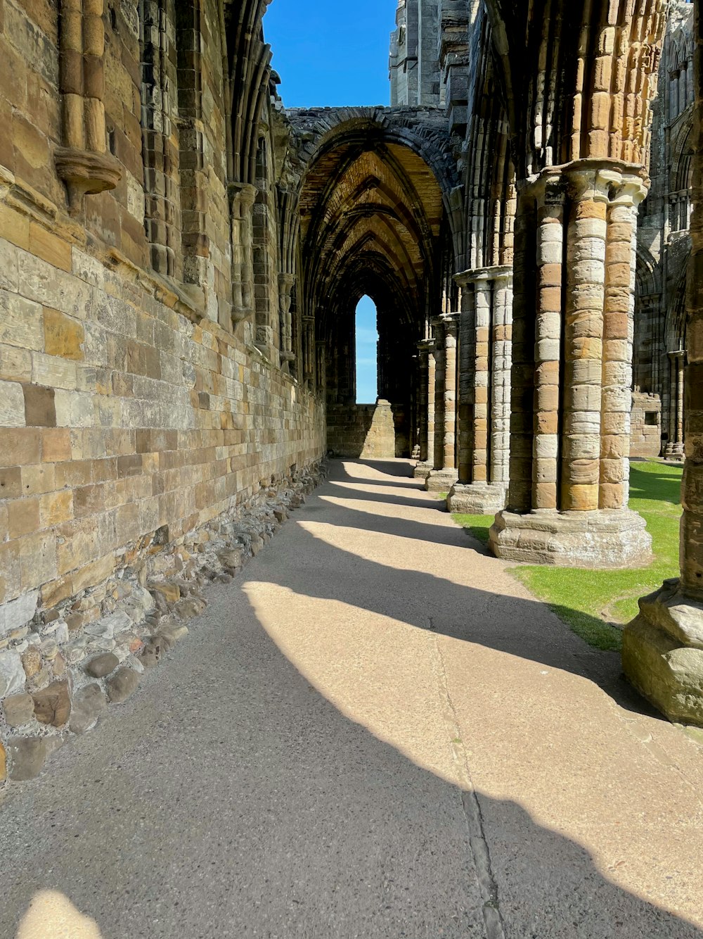 a stone building with arches and a walkway between it