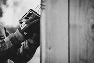 a black and white photo of a person holding a cell phone