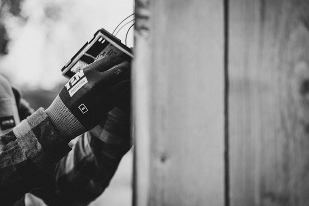 a black and white photo of a person holding a cell phone