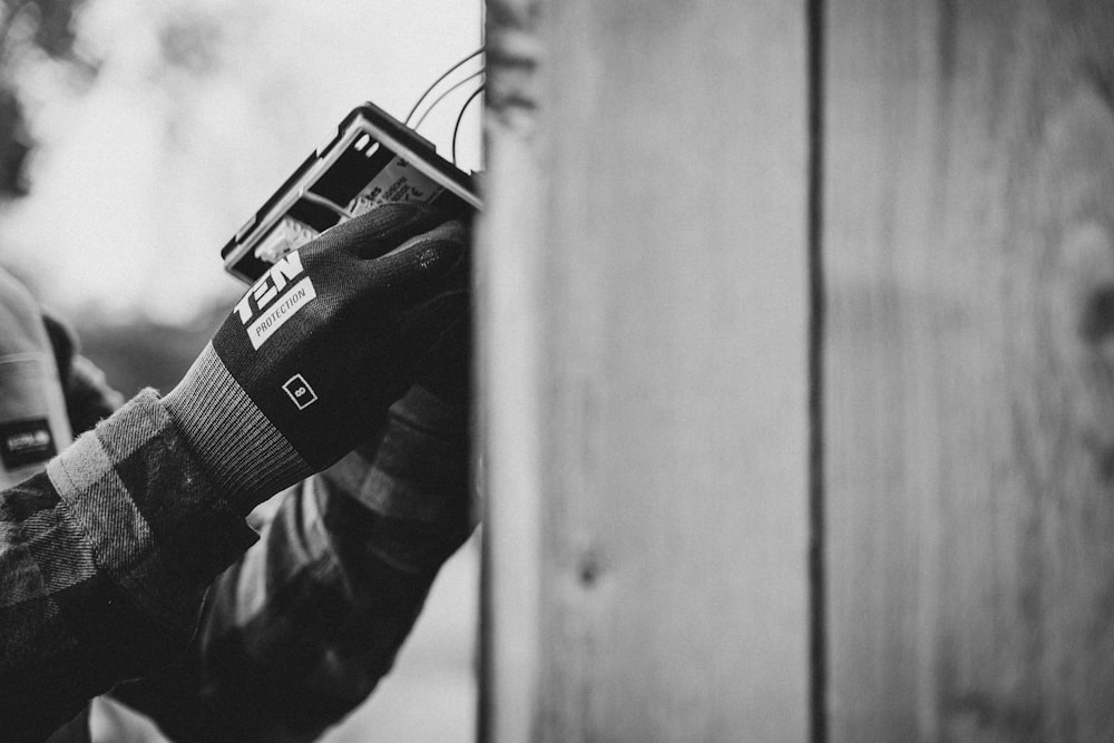 a black and white photo of a person holding a cell phone