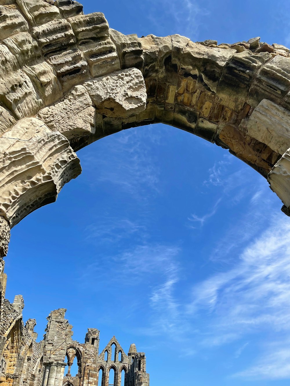 a stone arch with a blue sky in the background