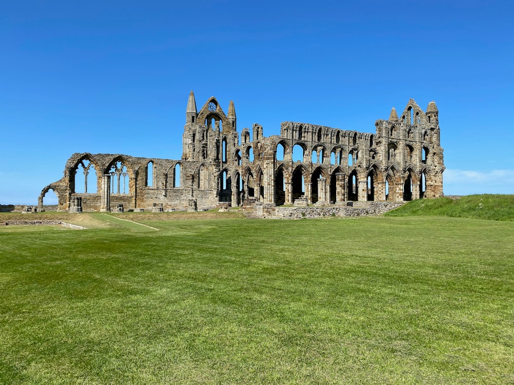 a large stone building sitting on top of a lush green field