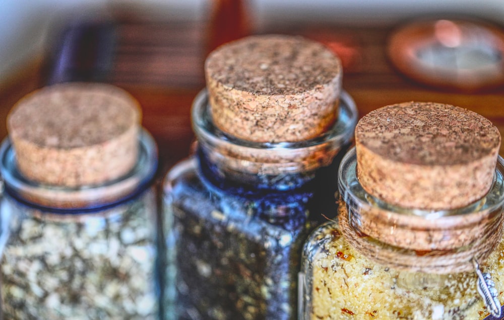 three jars filled with different types of spices