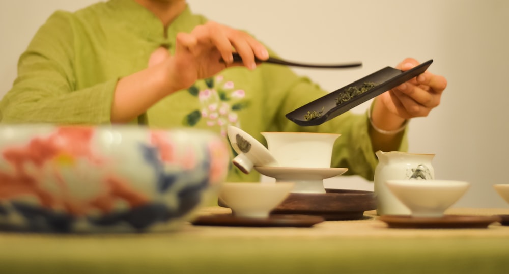 a woman sitting at a table with a knife in her hand