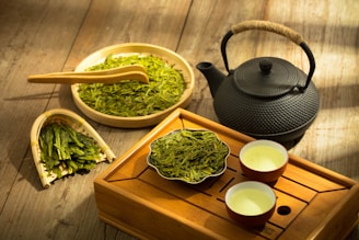 a tea set with a teapot and two cups of green tea