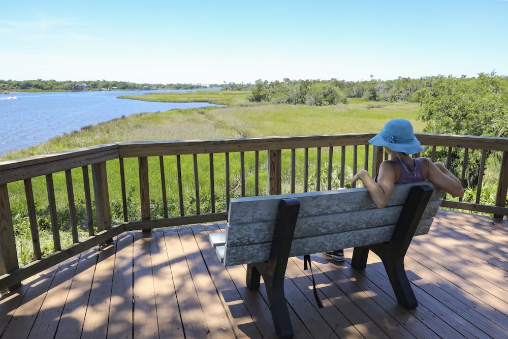 a woman sitting on a bench on a deck