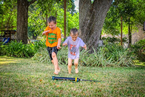 A family enjoying their backyard with newly installed turf, kids playing barefoot.