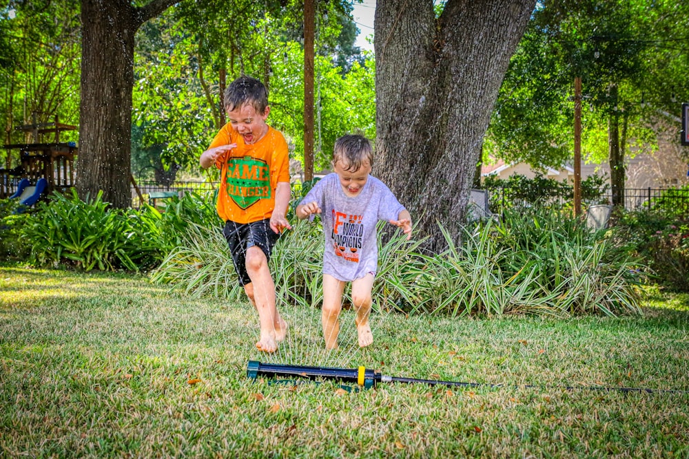 two young boys playing a game of croquet in a yard