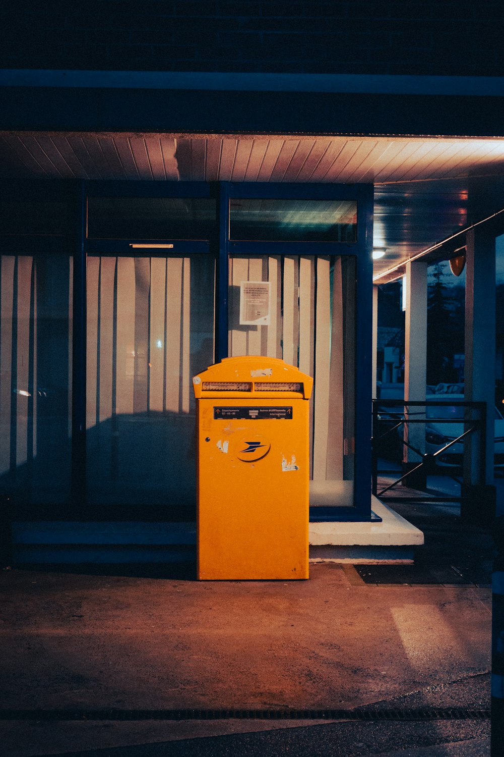 a yellow trash can sitting in front of a building