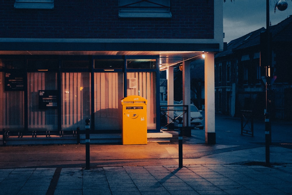 a yellow trash can sitting in front of a building