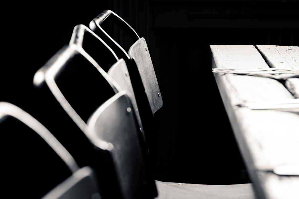 a row of chairs sitting next to a wooden table