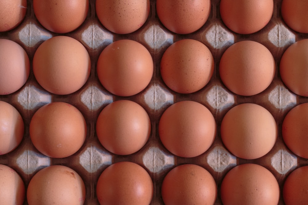 a bunch of brown eggs in a carton