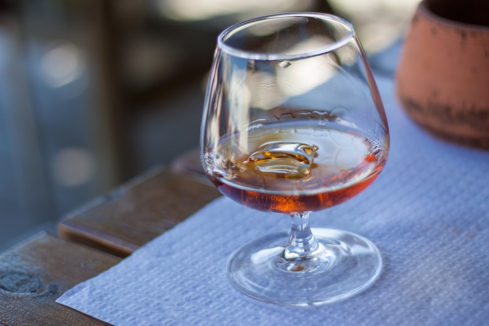 a glass of wine sitting on top of a wooden table