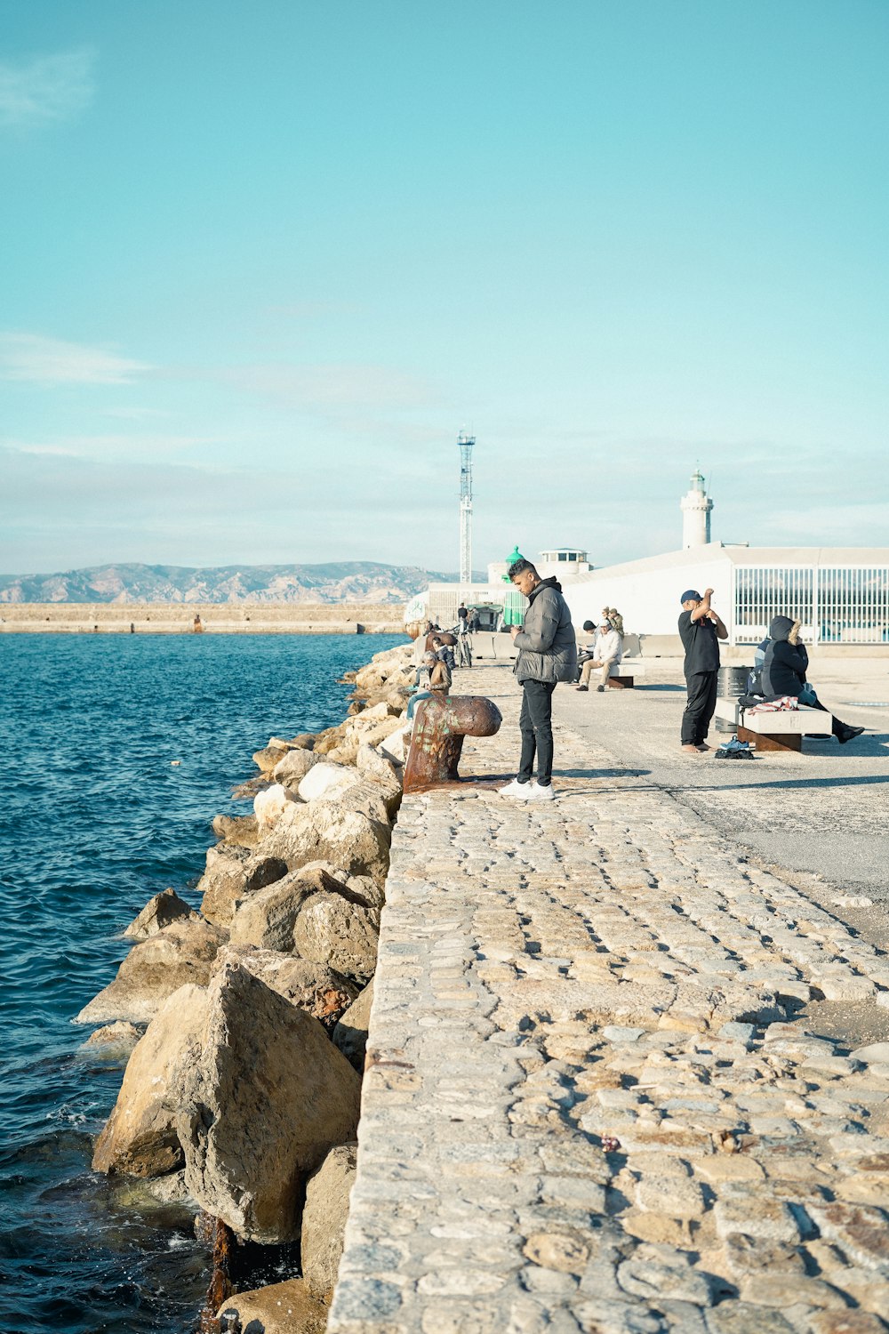 a group of people standing next to a body of water