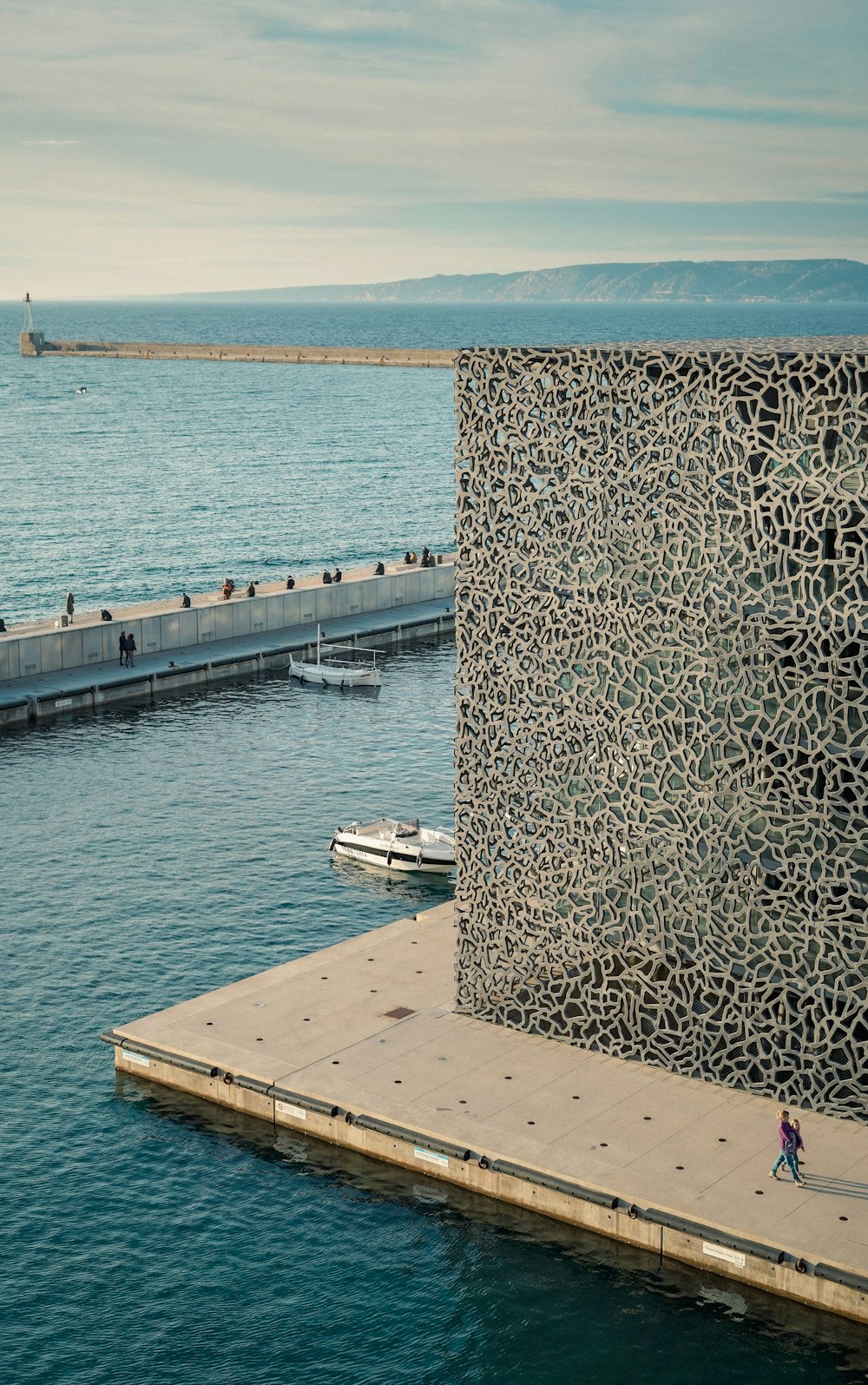 a person walking on a pier next to a body of water