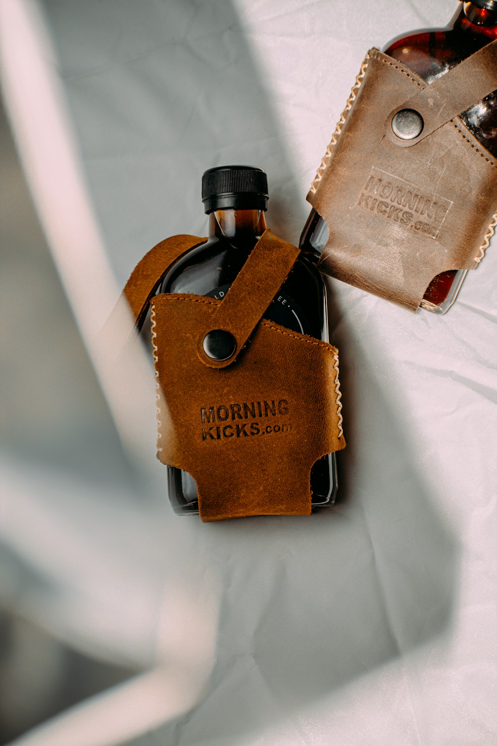 a leather flask case with a bottle opener